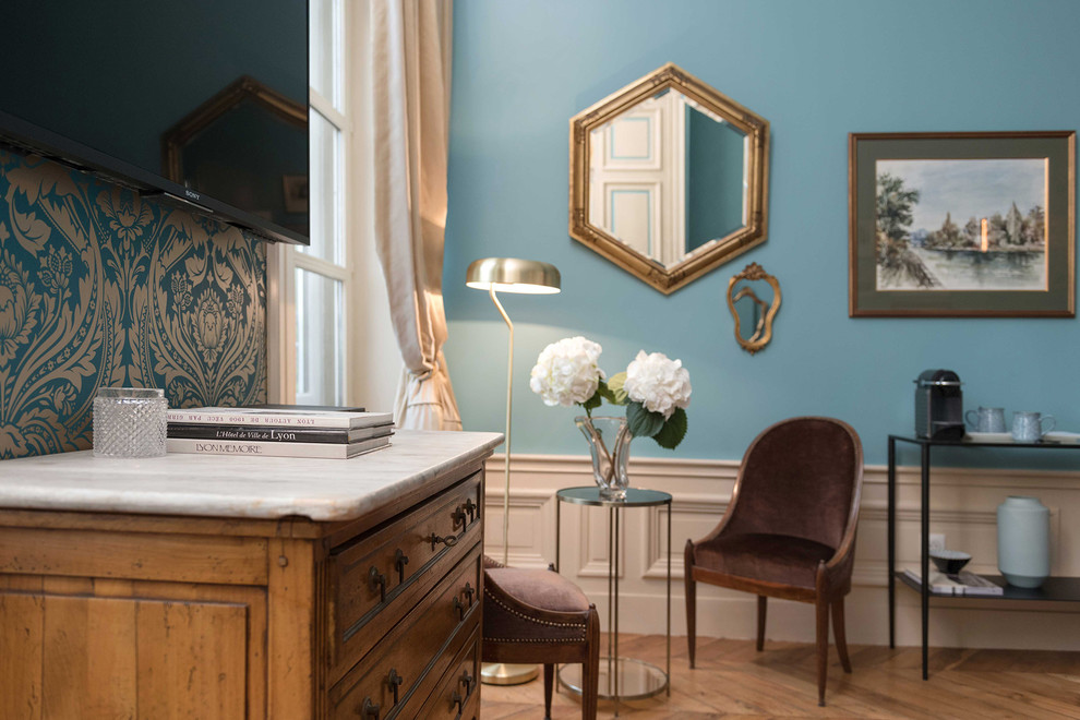 Idée de décoration pour une chambre d'amis victorienne de taille moyenne avec un mur bleu, parquet clair et un sol beige.