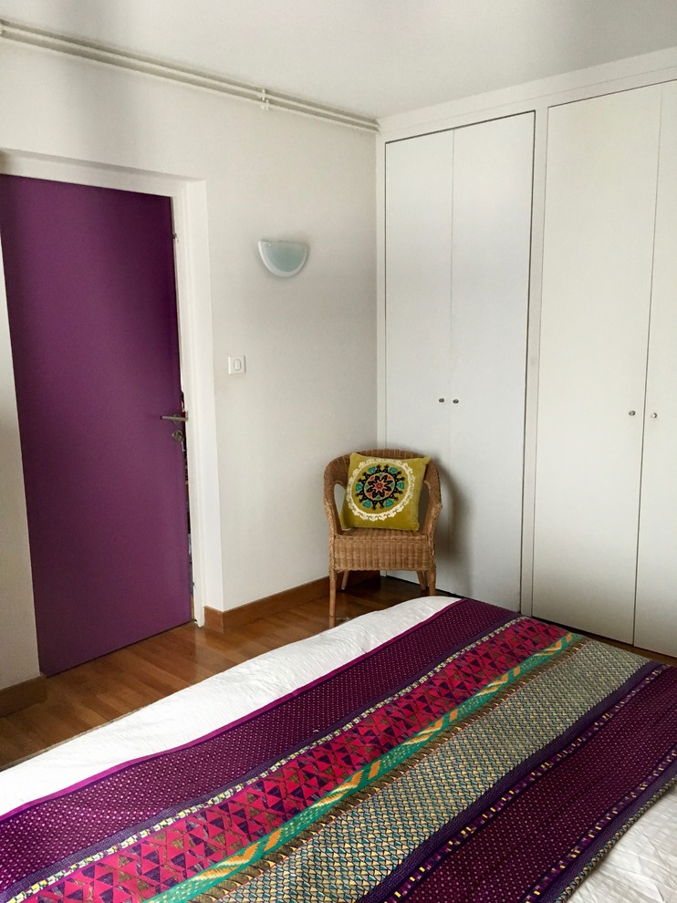 Esempio di una camera matrimoniale tropicale di medie dimensioni con pareti viola, parquet scuro e pavimento marrone