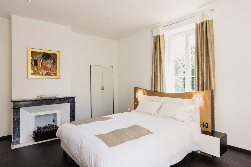 На фото: хозяйская спальня среднего размера в современном стиле с белыми стенами и темным паркетным полом