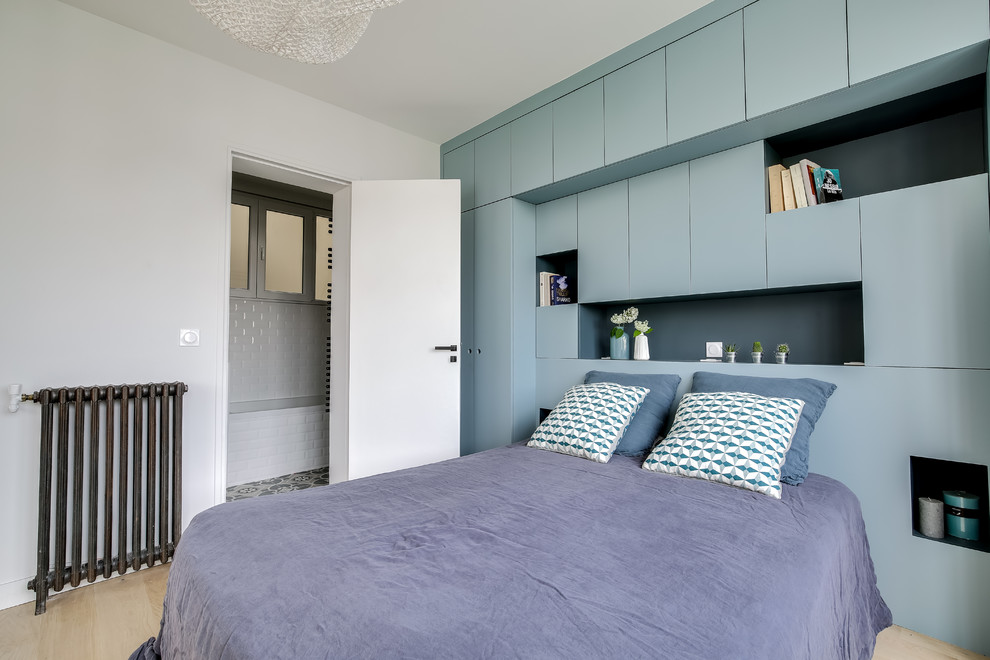 Esempio di una camera da letto minimal di medie dimensioni con pareti bianche, parquet chiaro e pavimento beige