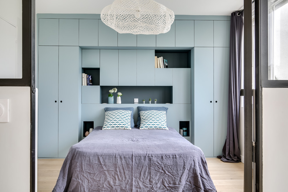 Immagine di una camera da letto industriale di medie dimensioni con pareti bianche, parquet chiaro e pavimento beige