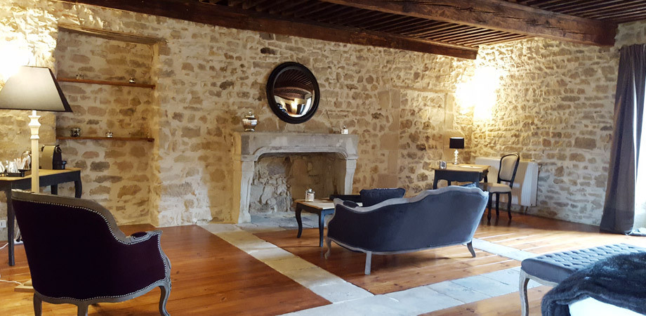 Ejemplo de dormitorio principal clásico renovado extra grande con suelo de madera clara, todas las chimeneas, marco de chimenea de piedra, suelo marrón y paredes beige