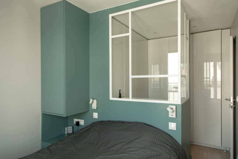 Idées déco pour une chambre parentale contemporaine de taille moyenne avec un mur bleu, parquet clair, aucune cheminée et un sol beige.
