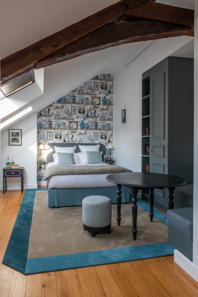 Foto de dormitorio principal y gris y blanco clásico renovado grande sin chimenea con paredes blancas, suelo marrón, vigas vistas y suelo de madera clara