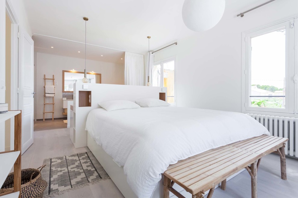 Modelo de dormitorio principal escandinavo grande con paredes blancas y suelo de madera clara
