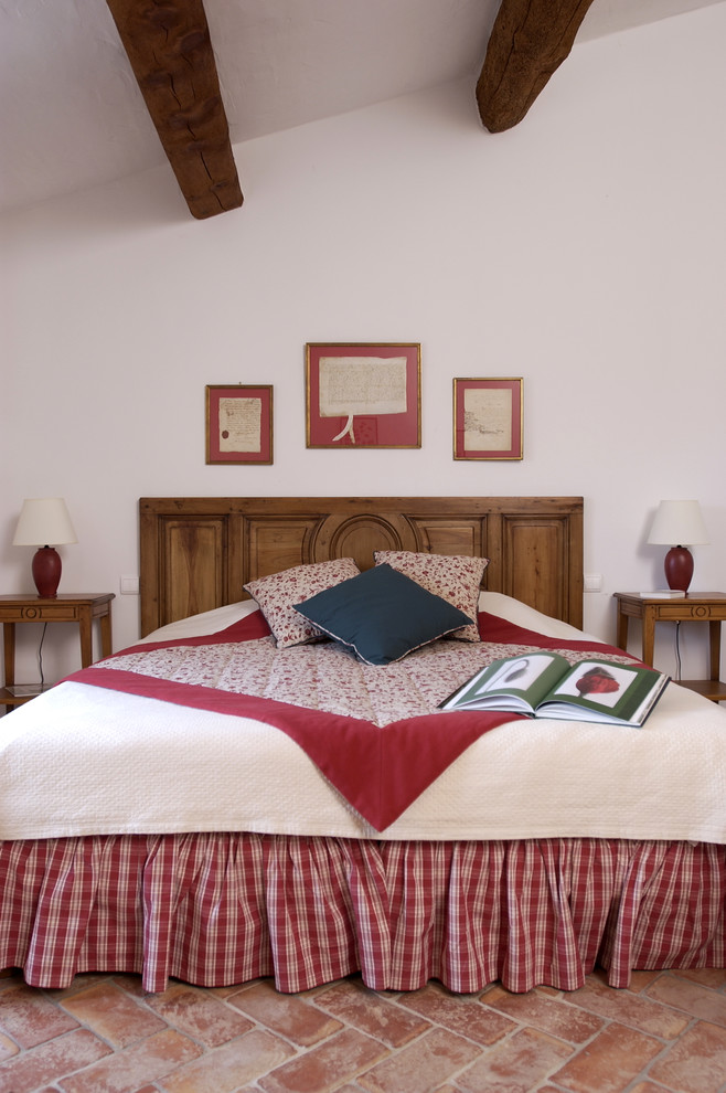 Diseño de habitación de invitados tradicional de tamaño medio con paredes blancas, suelo de baldosas de terracota y techo inclinado