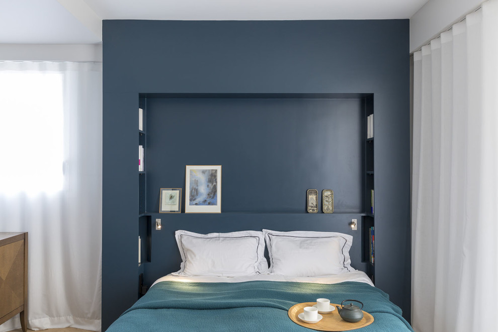 Mittelgroßes Modernes Hauptschlafzimmer mit blauer Wandfarbe und hellem Holzboden in Paris