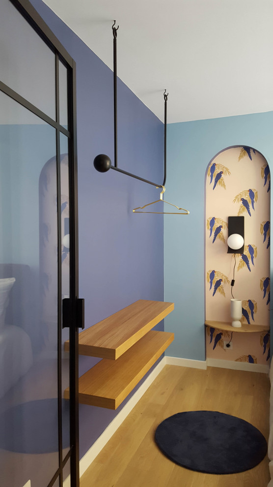 Inspiration pour une chambre parentale bohème de taille moyenne avec un mur bleu et parquet clair.