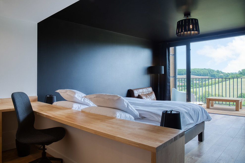Diseño de dormitorio principal actual grande con paredes negras, suelo de madera en tonos medios y suelo marrón