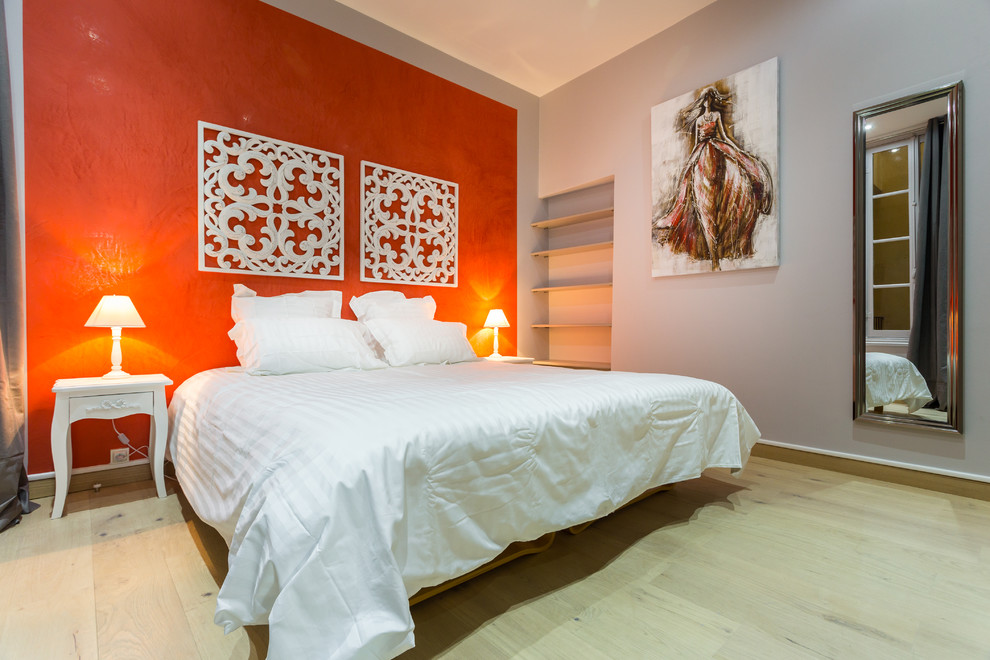 На фото: хозяйская спальня среднего размера в стиле фьюжн с светлым паркетным полом и оранжевыми стенами