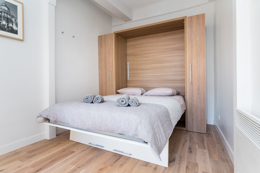 Modelo de habitación de invitados escandinava pequeña con paredes blancas y suelo de madera clara
