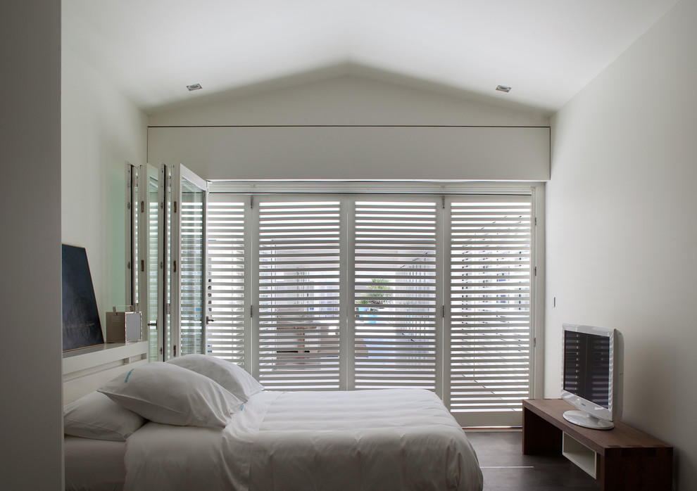 Modelo de dormitorio principal minimalista de tamaño medio con paredes blancas
