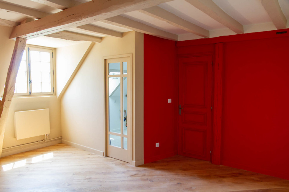 Inspiration for a medium sized modern master bedroom with red walls, light hardwood flooring and a standard fireplace.
