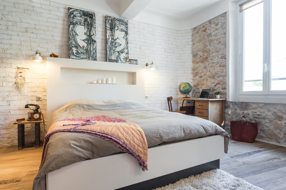 Esempio di una camera da letto mediterranea con parquet chiaro