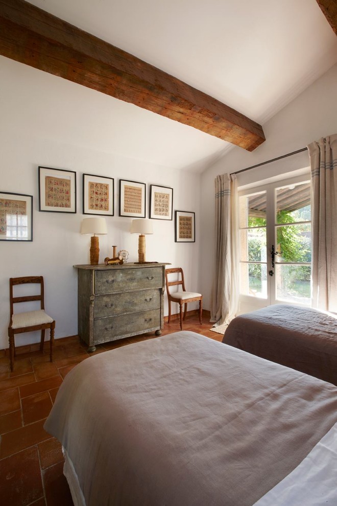 Diseño de habitación de invitados mediterránea sin chimenea con paredes blancas