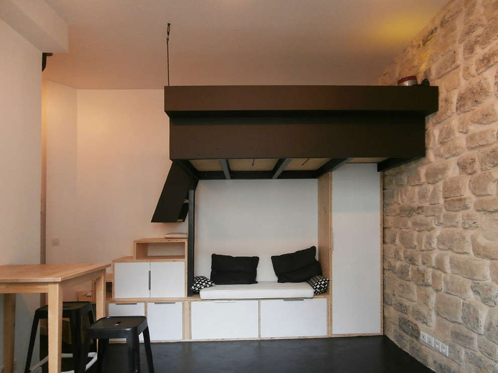 На фото: маленькая спальня на антресоли в стиле лофт с белыми стенами и бетонным полом для на участке и в саду