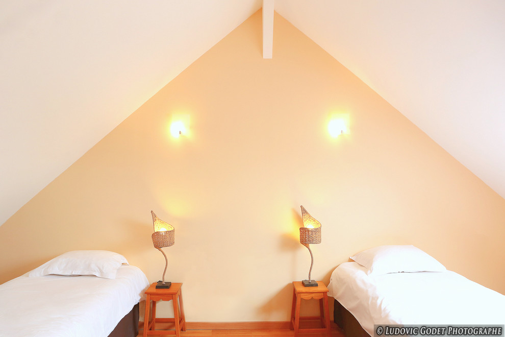 Ispirazione per una camera da letto stile marinaro con pareti beige e pavimento in legno massello medio