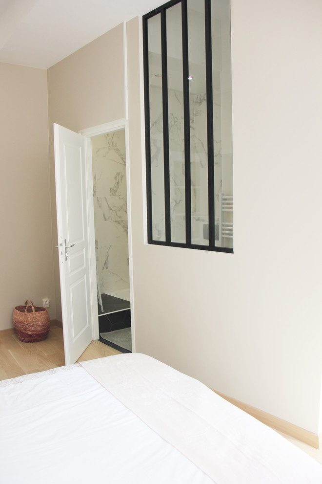 Imagen de dormitorio principal retro pequeño sin chimenea con paredes beige, suelo de madera clara y suelo beige