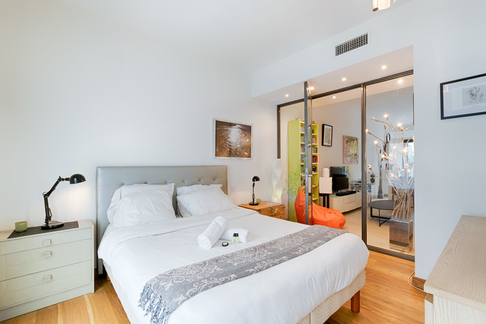 На фото: большая гостевая спальня (комната для гостей) в современном стиле с белыми стенами, светлым паркетным полом и коричневым полом