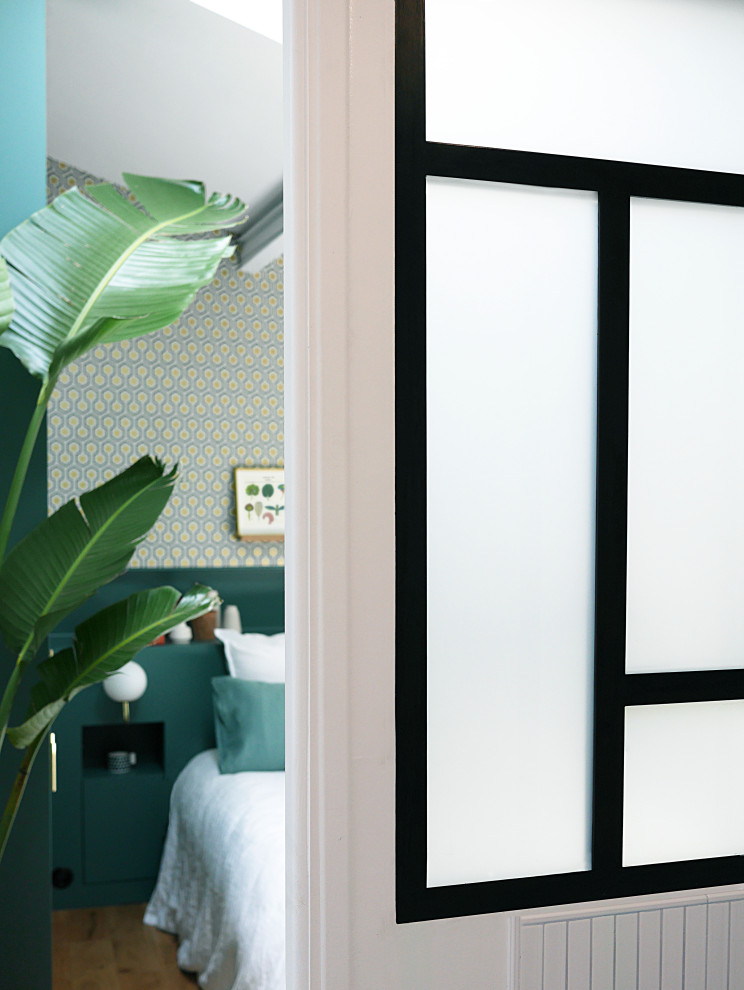 Cette image montre une chambre d'amis minimaliste de taille moyenne avec un mur bleu, parquet clair et un sol beige.
