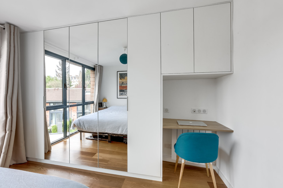 Idéer för ett litet modernt huvudsovrum, med vita väggar, plywoodgolv och beiget golv