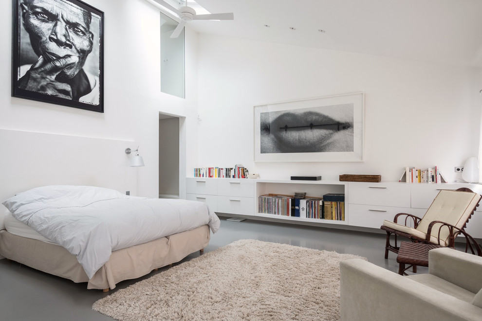 Exemple d'une grande chambre parentale tendance avec un mur blanc, sol en béton ciré, un sol gris et aucune cheminée.