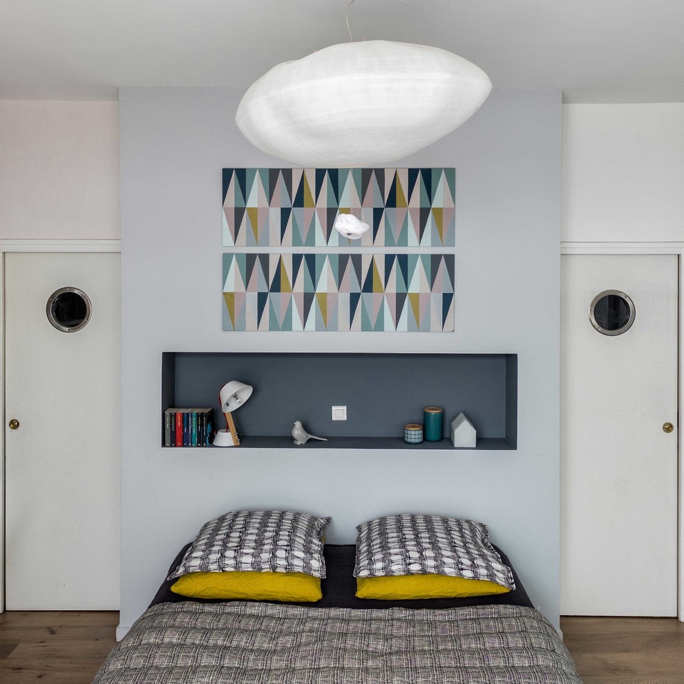 パリにある中くらいな北欧スタイルのおしゃれな主寝室 (グレーの壁、無垢フローリング)