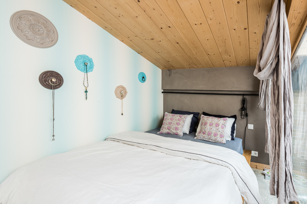 Immagine di una camera da letto minimal di medie dimensioni con pareti grigie, pavimento in cemento e nessun camino