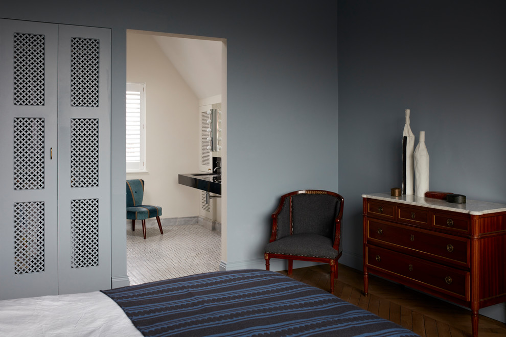 Imagen de dormitorio principal tradicional de tamaño medio con paredes azules, suelo de madera en tonos medios y suelo beige