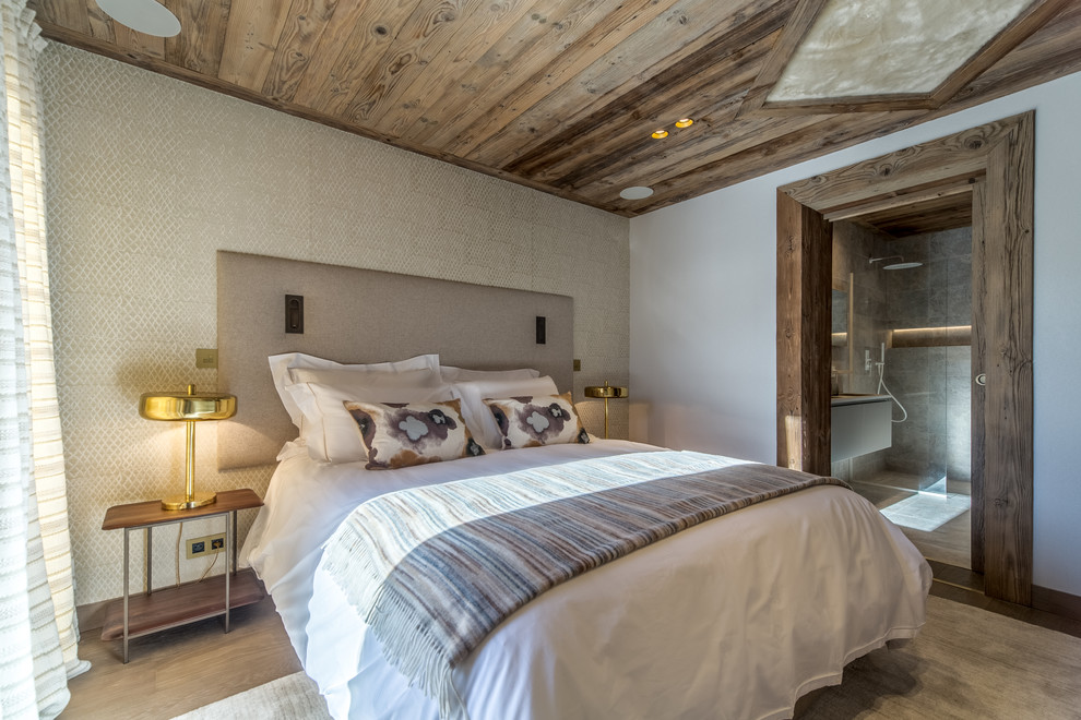 Ejemplo de dormitorio principal rústico grande con paredes beige, suelo de madera en tonos medios y suelo marrón