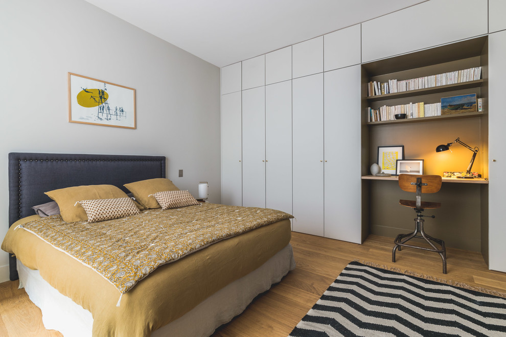 Пример оригинального дизайна: спальня в современном стиле с белыми стенами, паркетным полом среднего тона и коричневым полом