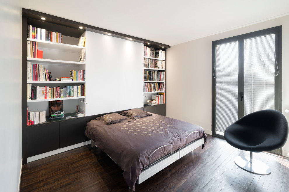 Foto de dormitorio principal actual de tamaño medio sin chimenea con paredes beige, suelo de madera en tonos medios y suelo marrón