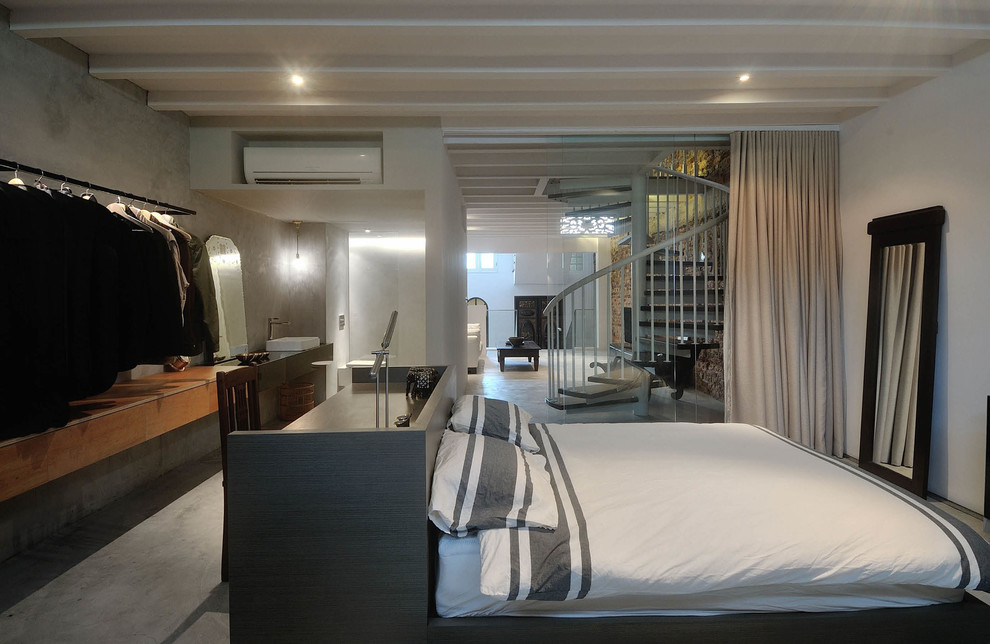 Esempio di una camera degli ospiti moderna di medie dimensioni con pareti bianche e pavimento in cemento