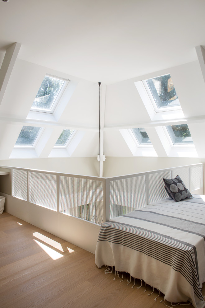 Exemple d'une chambre mansardée ou avec mezzanine blanche et bois scandinave avec un mur blanc, un sol en bois brun, un sol marron, un plafond voûté et verrière.