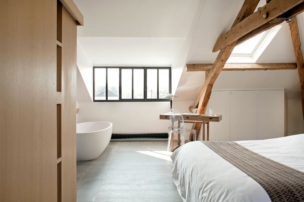 Réalisation d'une salle d'eau blanche et bois design en bois brun avec un placard à porte plane, une baignoire posée, un mur blanc, parquet peint, un plan de toilette en bois, un sol gris et poutres apparentes.