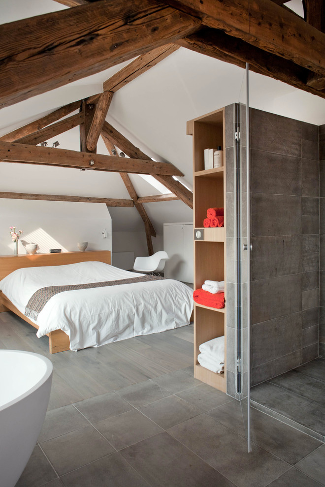 Modern inredning av ett sovrum, med vita väggar och mellanmörkt trägolv