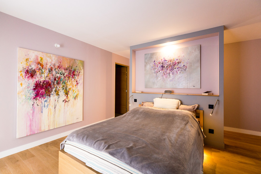Inspiration pour une grande chambre parentale design avec un mur rose et parquet clair.