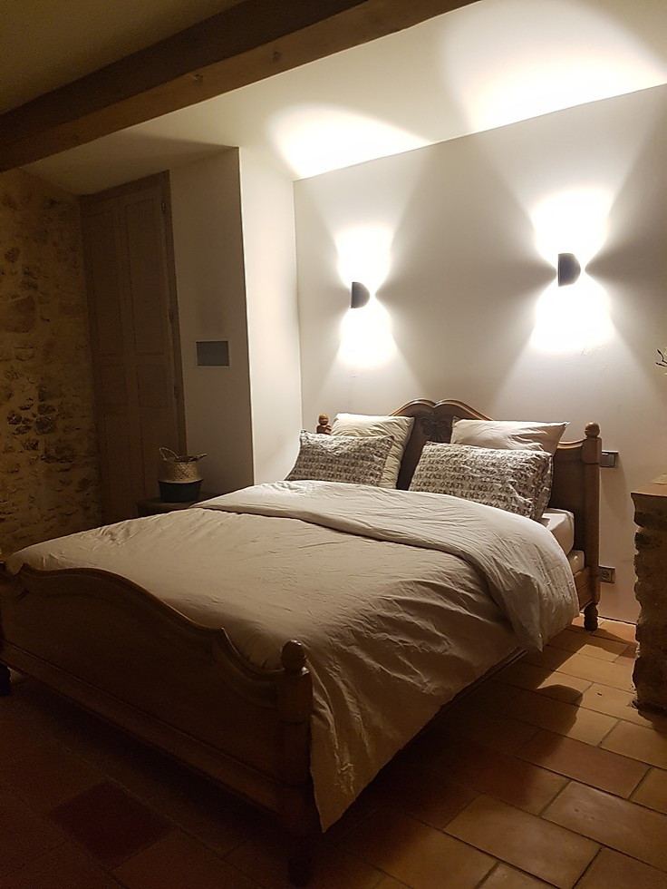 Пример оригинального дизайна: большая хозяйская спальня в стиле кантри с полом из терракотовой плитки, подвесным камином и фасадом камина из металла