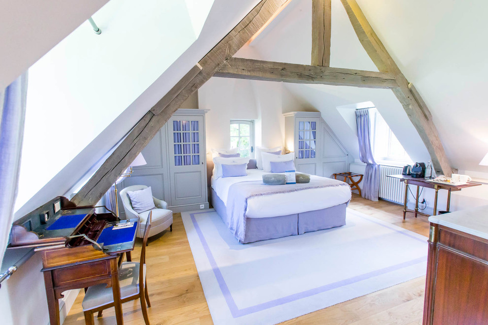 Diseño de dormitorio principal y blanco y madera clásico grande sin chimenea con paredes blancas, suelo de madera clara y suelo marrón