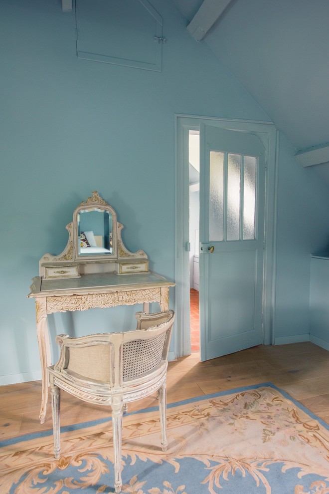 Diseño de habitación de invitados de estilo de casa de campo de tamaño medio sin chimenea con paredes azules, suelo de madera clara y suelo azul