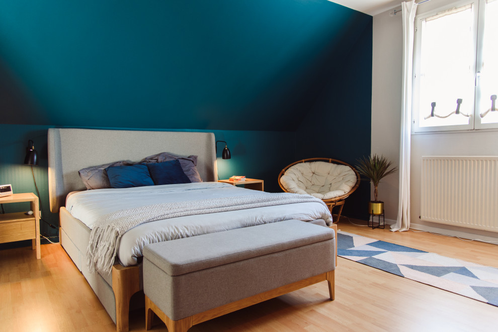 ナントにある広いモダンスタイルのおしゃれな主寝室 (青い壁、淡色無垢フローリング、暖炉なし、茶色い床)
