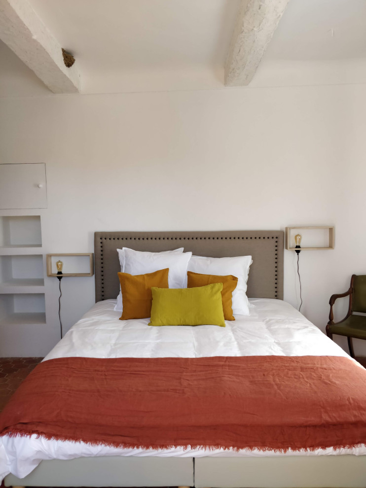 Свежая идея для дизайна: гостевая спальня среднего размера, (комната для гостей) в средиземноморском стиле с серыми стенами, полом из терракотовой плитки, красным полом и балками на потолке без камина - отличное фото интерьера