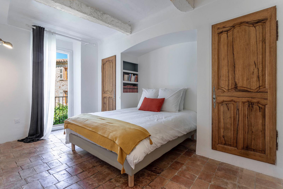 Imagen de dormitorio mediterráneo de tamaño medio con suelo de baldosas de terracota