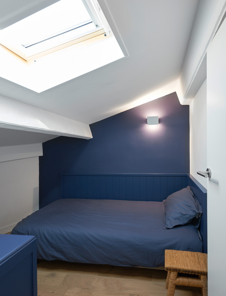 Inspiration för ett mellanstort maritimt sovloft, med blå väggar och ljust trägolv