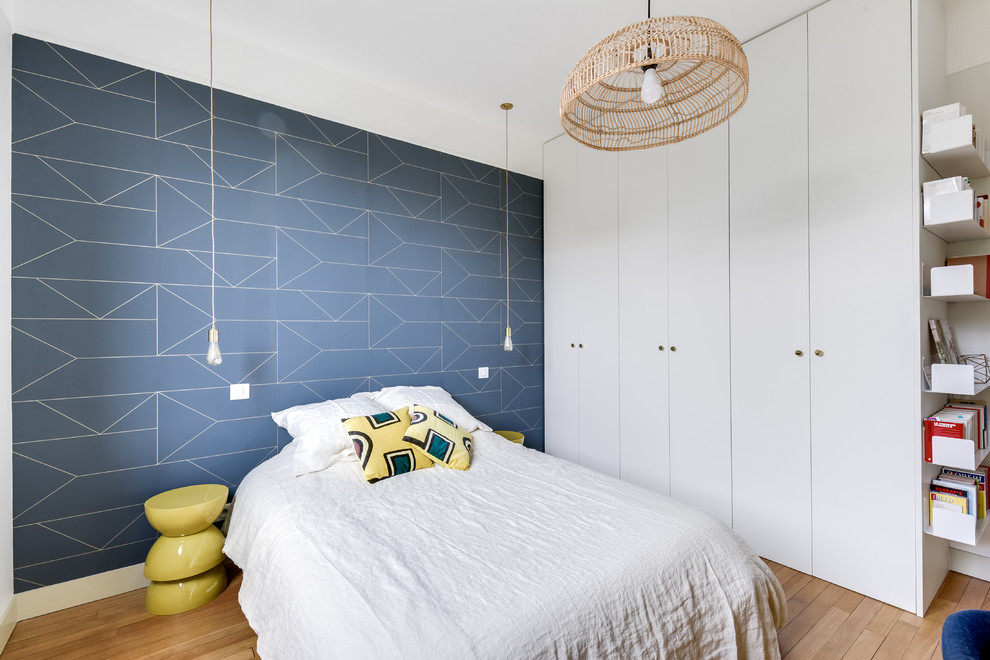 Foto di una camera da letto classica con pareti blu, parquet chiaro e nessun camino