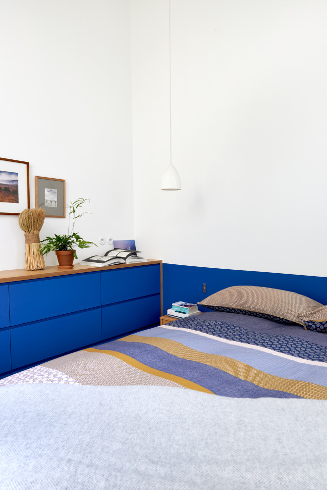 Ejemplo de dormitorio principal contemporáneo de tamaño medio con paredes azules y suelo marrón