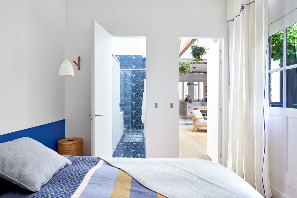 Réalisation d'une chambre parentale de taille moyenne avec un mur bleu et un sol marron.
