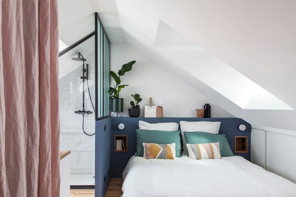 Ejemplo de dormitorio nórdico pequeño sin chimenea con suelo de madera clara y paredes blancas