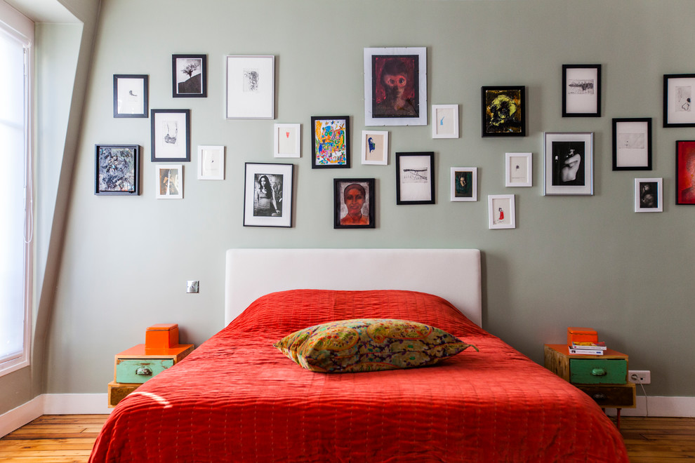 Esempio di una camera da letto design con pareti grigie e pavimento in legno massello medio