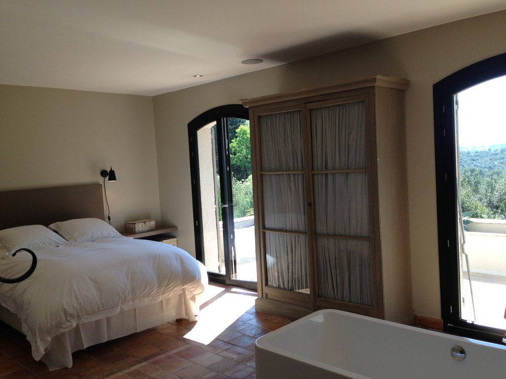 Стильный дизайн: большая хозяйская спальня в морском стиле с бежевыми стенами, полом из терракотовой плитки и оранжевым полом - последний тренд